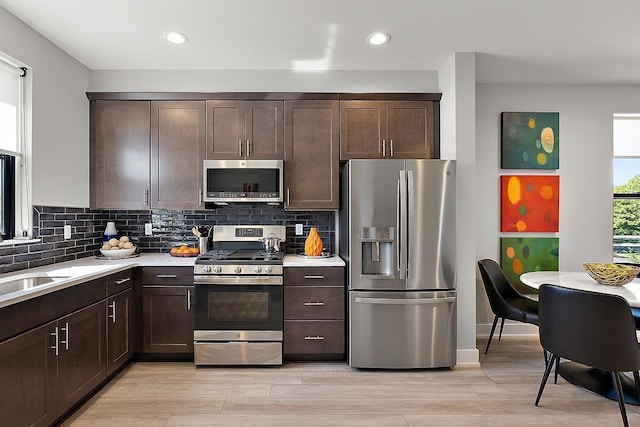 1737 Merrick St # 12, Detroit, MI 48208 - kitchen with appliances with stainless steel finishes, dark brown cabinets, light countertops, decorative backsplash, and recessed lighting