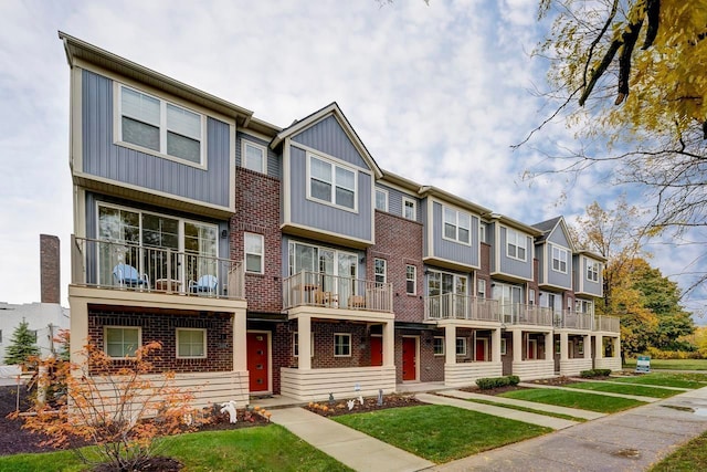1737 Merrick St # 12, Detroit, MI 48208 - multi unit property featuring a residential view, brick siding, a front lawn, board and batten siding, and a balcony