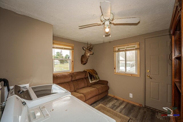 living room with a textured ceiling, ceiling fan, wood finished floors, and washer and dryer