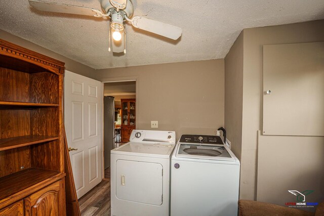 clothes washing area featuring a textured ceiling, separate washer and dryer, a ceiling fan, and wood finished floors