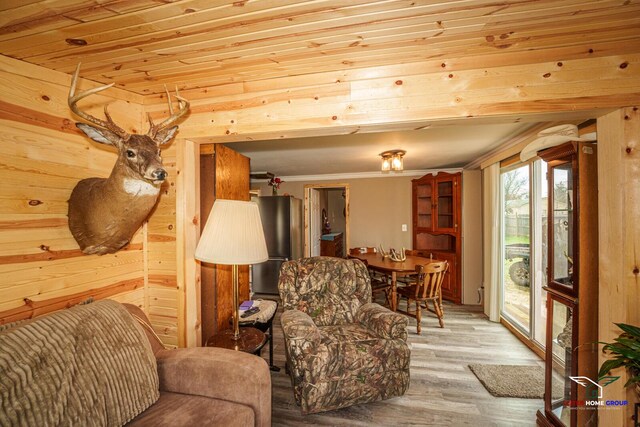 living area featuring crown molding, wood ceiling, wood walls, and wood finished floors