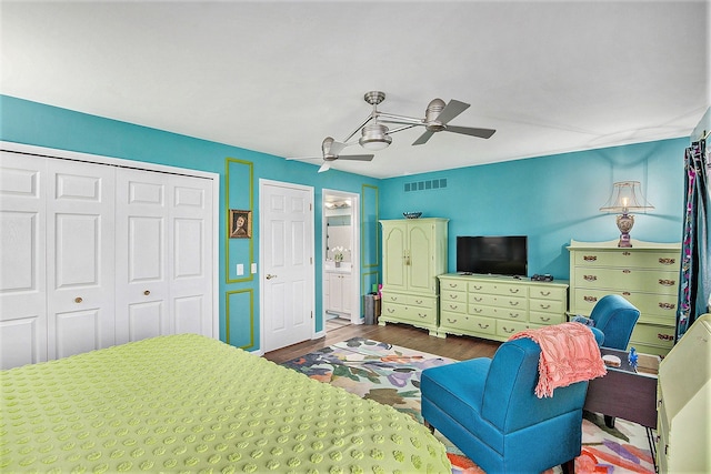 bedroom featuring visible vents, a ceiling fan, wood finished floors, a closet, and connected bathroom