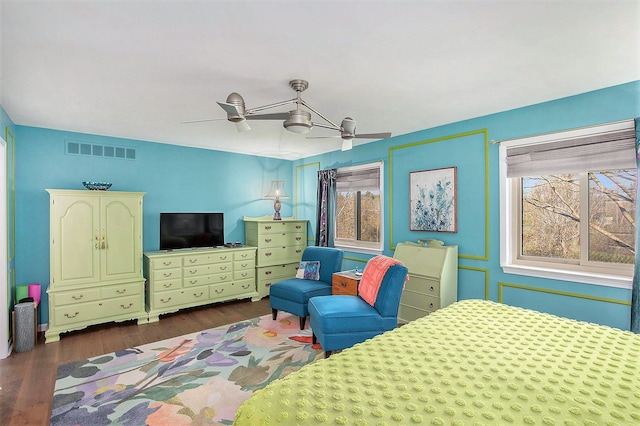bedroom featuring a ceiling fan, visible vents, and dark wood-style flooring