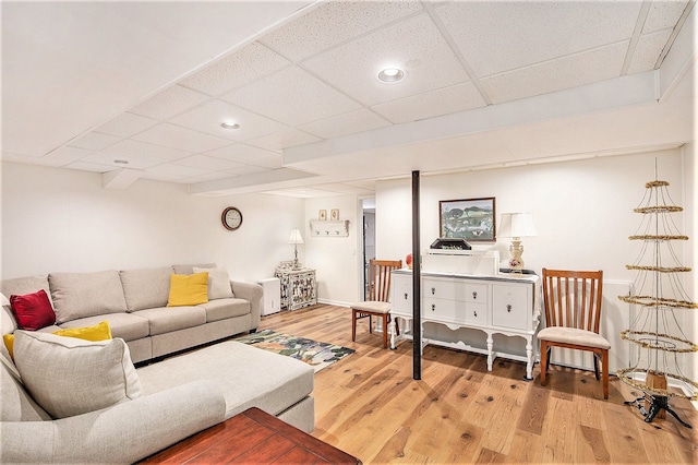 living area featuring baseboards, wood finished floors, a paneled ceiling, and recessed lighting