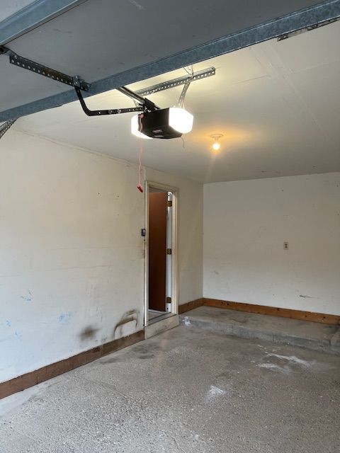 garage with a garage door opener and baseboards