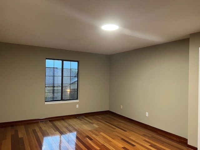 unfurnished room featuring baseboards and wood finished floors