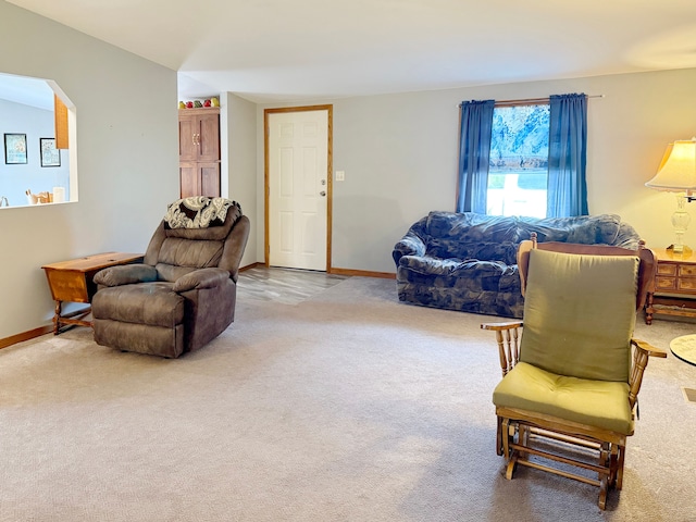 carpeted living room featuring baseboards