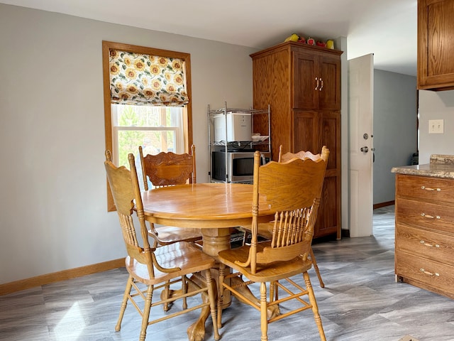 dining area featuring light floors and baseboards