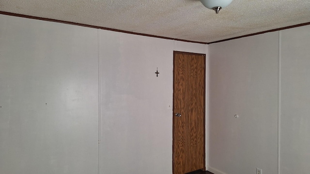unfurnished room with crown molding and a textured ceiling