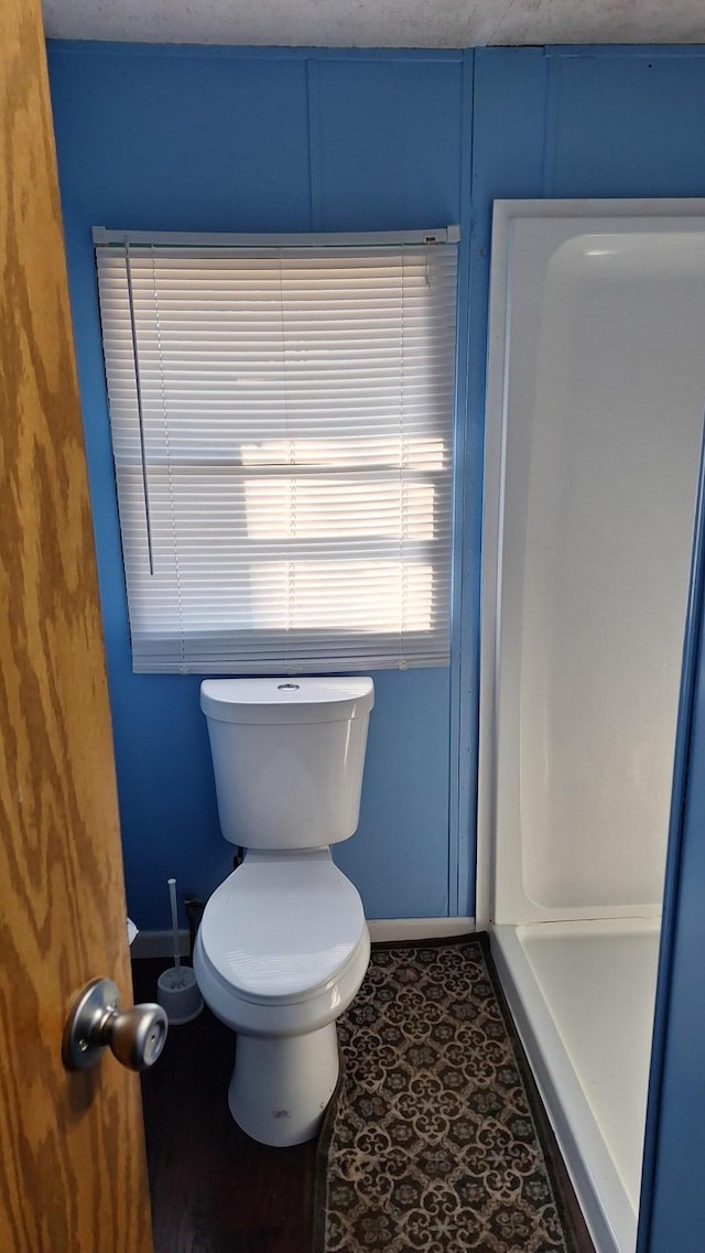 bathroom featuring baseboards and toilet