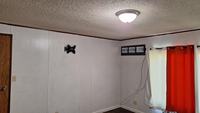 unfurnished room featuring wood finished floors and a textured ceiling