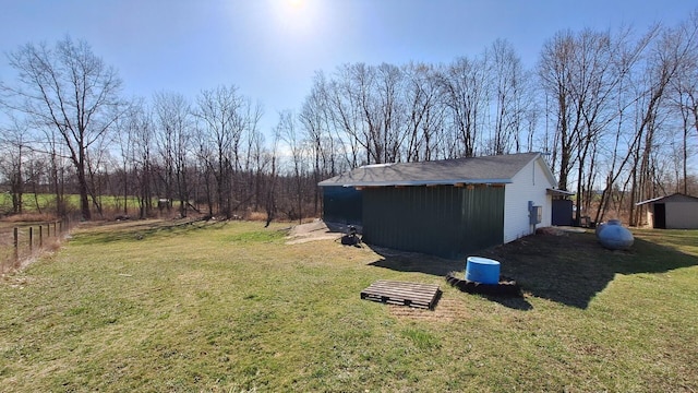 view of yard with fence and an outbuilding