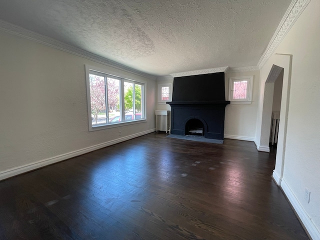 unfurnished living room with dark wood-type flooring, ornamental molding, radiator, and a textured ceiling