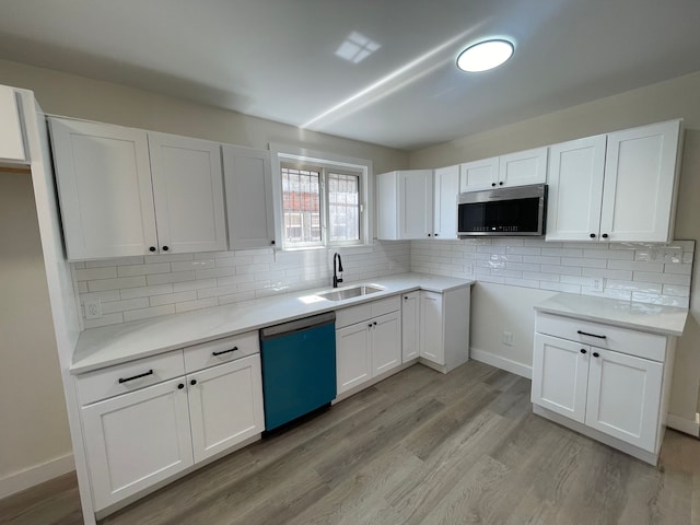 kitchen with decorative backsplash, a sink, white cabinets, stainless steel microwave, and dishwashing machine