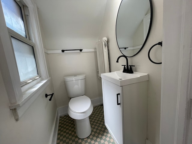 half bath featuring toilet, baseboards, tile patterned floors, and vanity