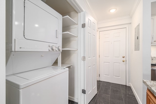 clothes washing area with stacked washer and dryer, laundry area, electric panel, baseboards, and crown molding