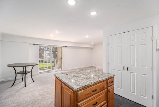 kitchen featuring light stone countertops, recessed lighting, brown cabinets, baseboards, and crown molding