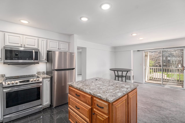 kitchen featuring white cabinets, light stone countertops, appliances with stainless steel finishes, and recessed lighting