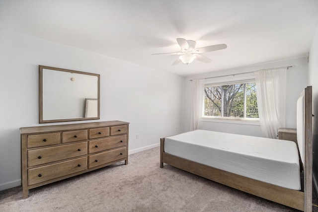 bedroom with light colored carpet, a ceiling fan, and baseboards