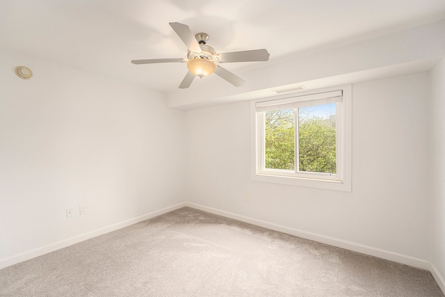 carpeted empty room featuring visible vents, ceiling fan, and baseboards