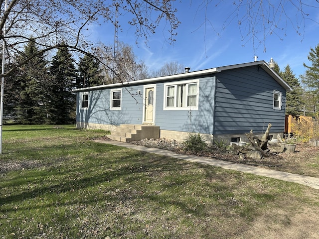 manufactured / mobile home with entry steps and a front lawn