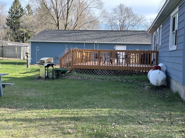 back of house featuring a yard, a deck, and a shingled roof