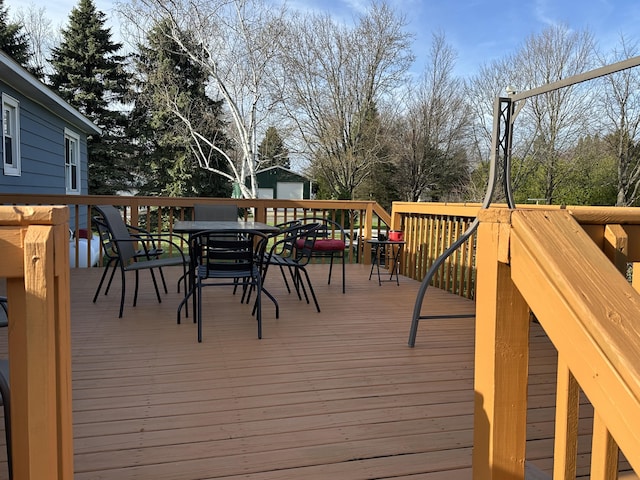 wooden deck with an outdoor structure and outdoor dining area