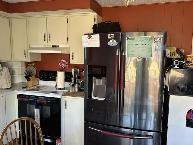kitchen featuring range with electric stovetop, under cabinet range hood, stainless steel fridge, and a decorative wall