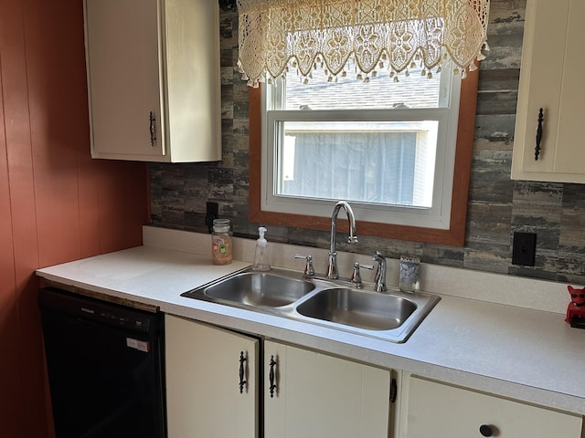 kitchen with white cabinets, dishwasher, light countertops, and a sink