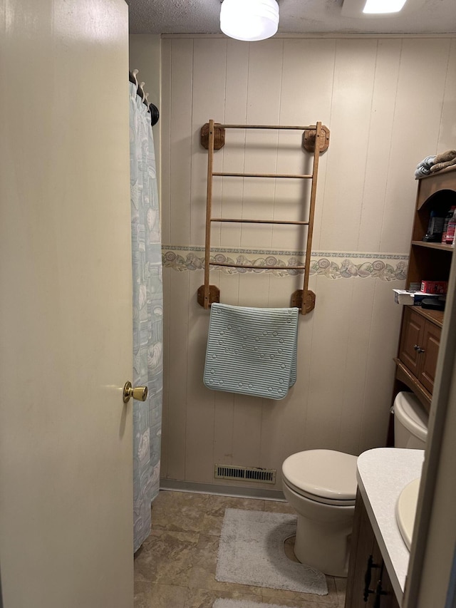 full bath with visible vents, vanity, a shower with shower curtain, and toilet