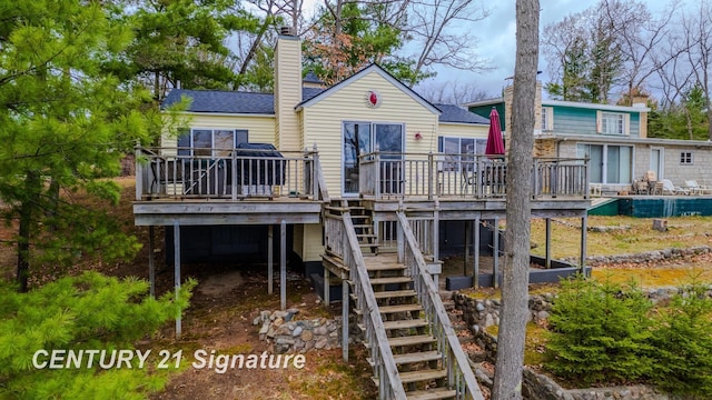 7765 Nicole Dr, South Branch, MI 48761 - back of property with a deck, a chimney, and stairs