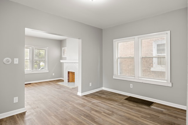 15100 Washburn St, Detroit, MI 48238 - unfurnished living room featuring baseboards, a tile fireplace, visible vents, and wood finished floors