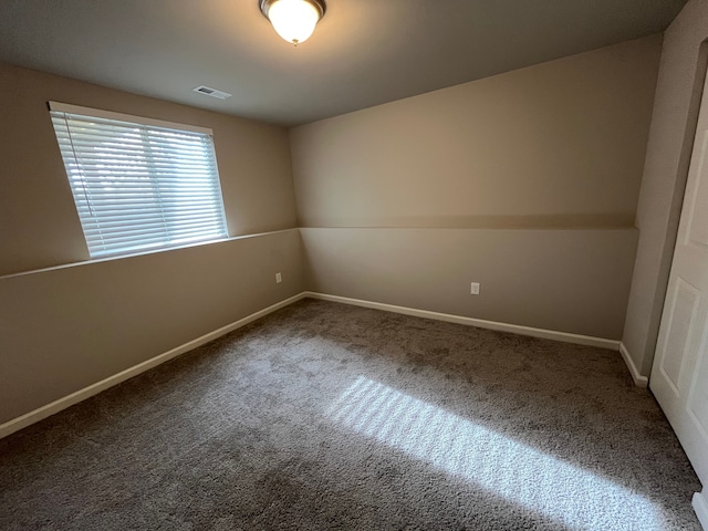 carpeted empty room featuring baseboards and visible vents