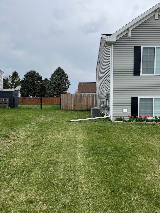 view of yard with fence and central AC unit