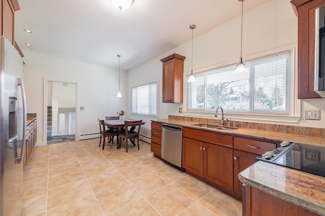 kitchen with a sink, appliances with stainless steel finishes, brown cabinets, and light stone counters
