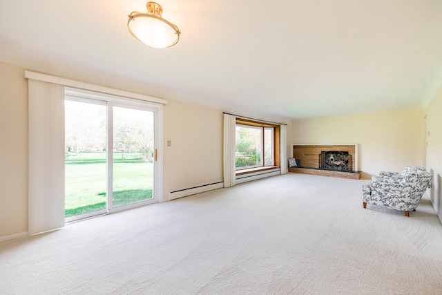 unfurnished living room with baseboards, carpet, a baseboard heating unit, and a fireplace