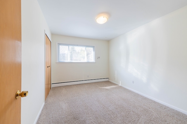 carpeted spare room featuring baseboards and baseboard heating