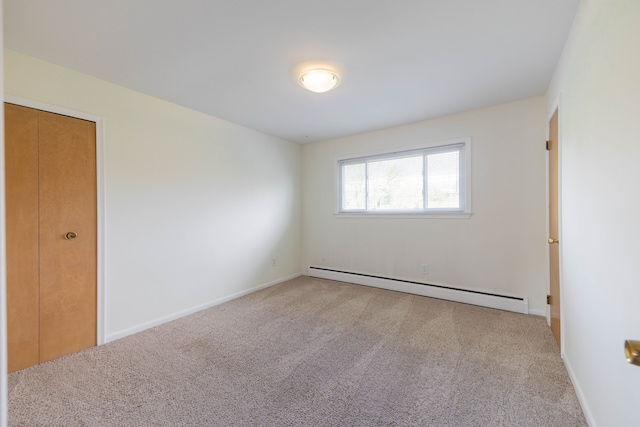 carpeted empty room with baseboards and a baseboard radiator