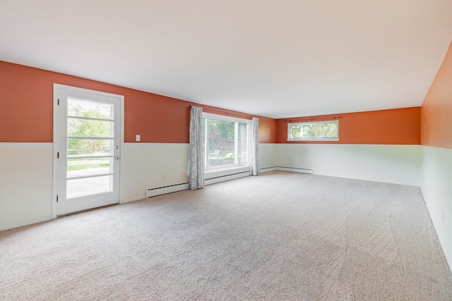 spare room featuring carpet floors, wainscoting, and baseboard heating