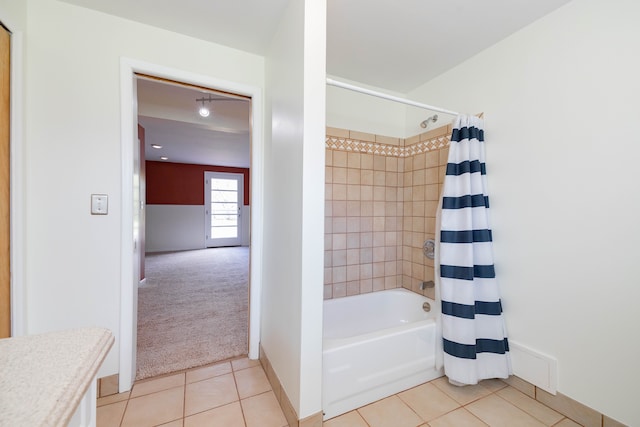bathroom with shower / bath combo with shower curtain, tile patterned floors, and baseboards