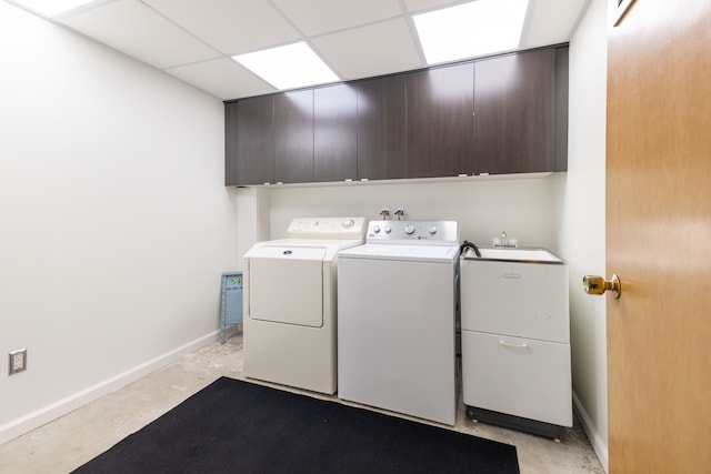 laundry room with separate washer and dryer, cabinet space, and baseboards