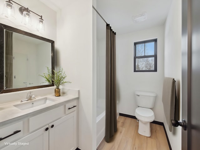 full bathroom with wood finished floors, shower / bathtub combination with curtain, toilet, vanity, and baseboards