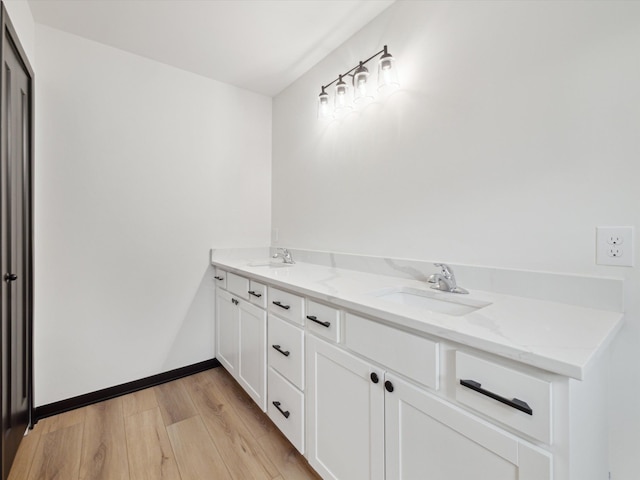 bathroom with wood finished floors, double vanity, and a sink