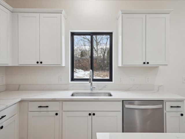 kitchen featuring stainless steel dishwasher, light stone countertops, a sink, and white cabinetry