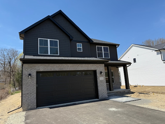 view of front of home featuring brick siding, driveway, and an attached garage