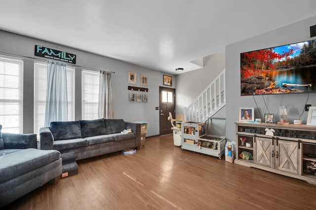 living room with wood finished floors and stairway