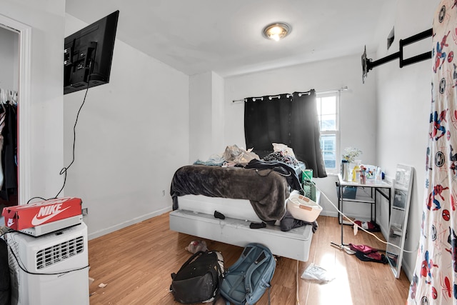 bedroom with baseboards and wood finished floors
