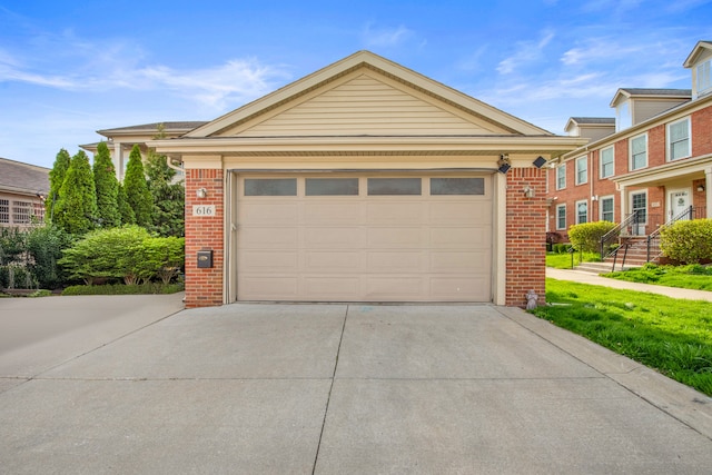 view of front of house featuring brick siding, a garage, and concrete driveway