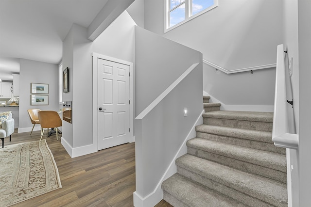 staircase with wood finished floors and baseboards