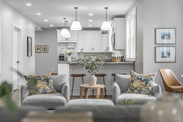 kitchen featuring pendant lighting, white cabinets, stainless steel appliances, recessed lighting, and wood finished floors